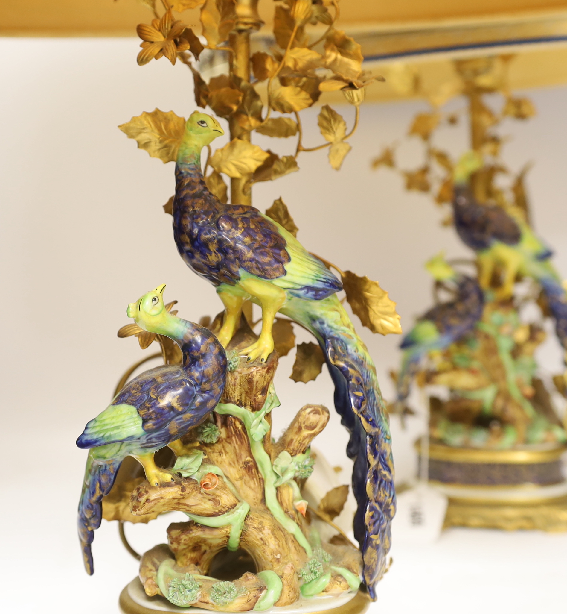 A pair of Sevres style porcelain and gilt metal ‘peacock’ lamps and shades, 60cm total height